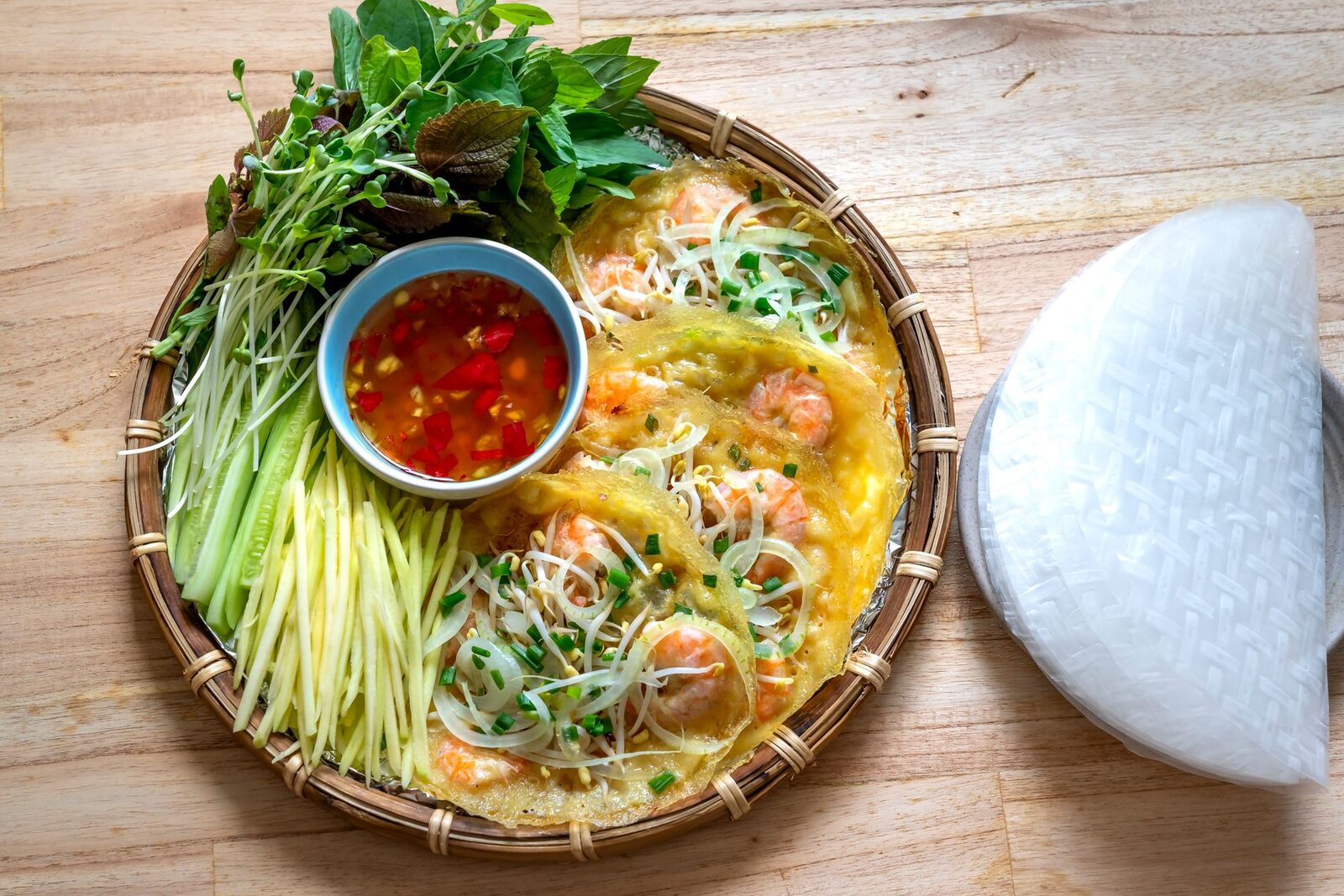 Bánh xèo miền Tây vàng giòn nhìn từ trên xuống, dọn cùng rau thơm và chén nước chấm